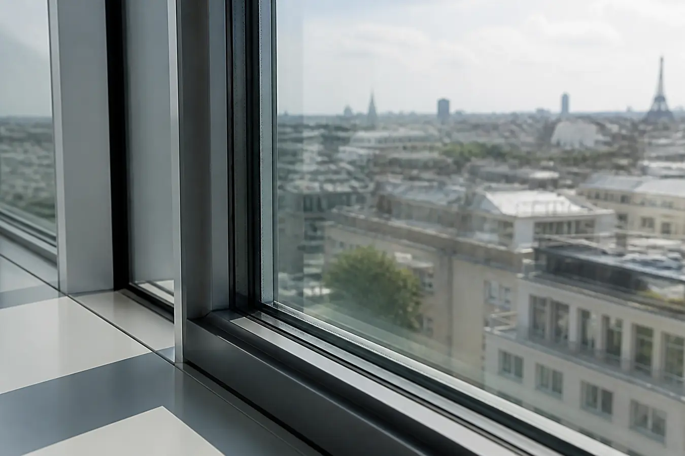 Double vitrage de bureau avec film solaire intérieur, vue sur toits franciliens