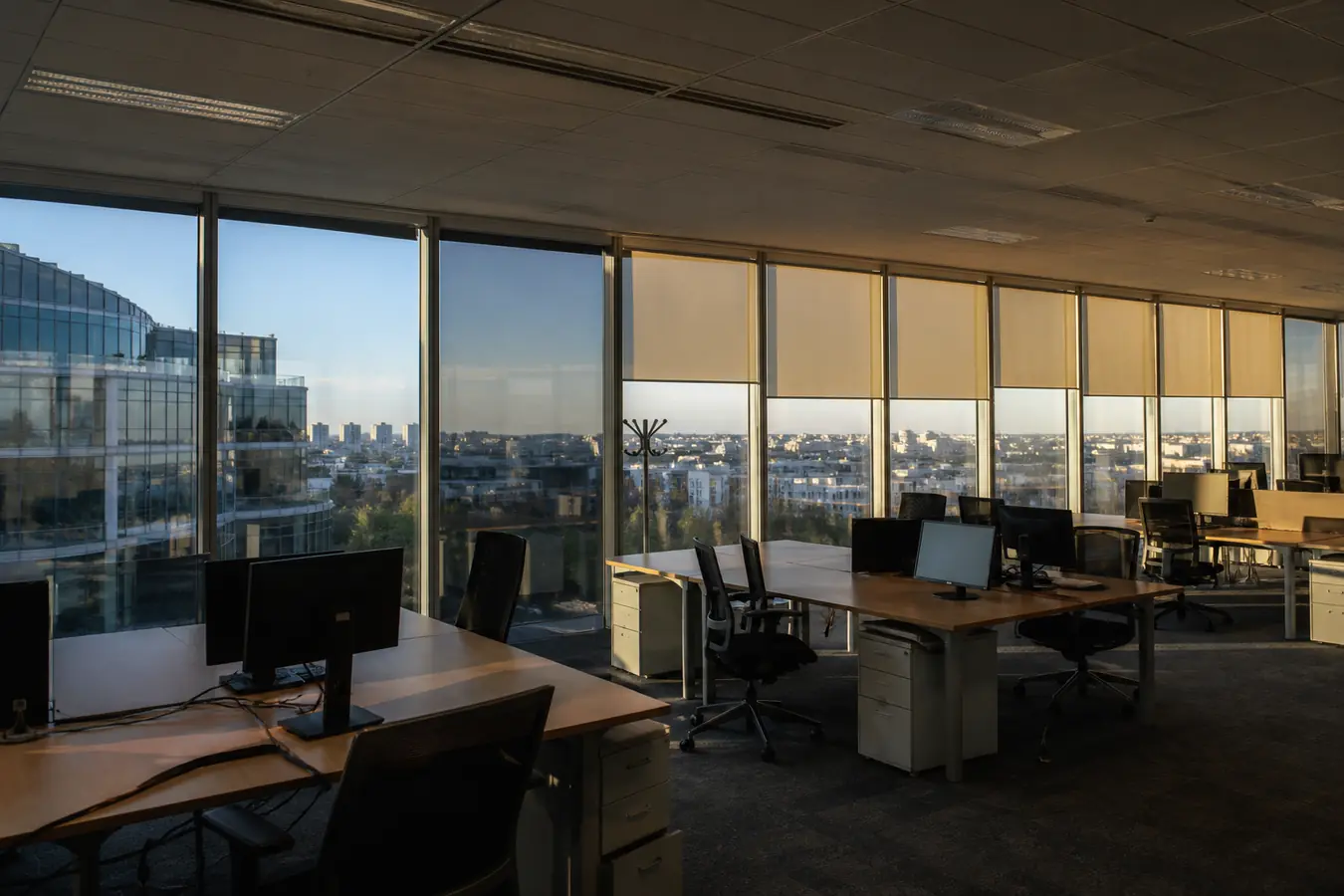 Open space francilien : baies avec film solaire et stores enrouleurs, même plateau